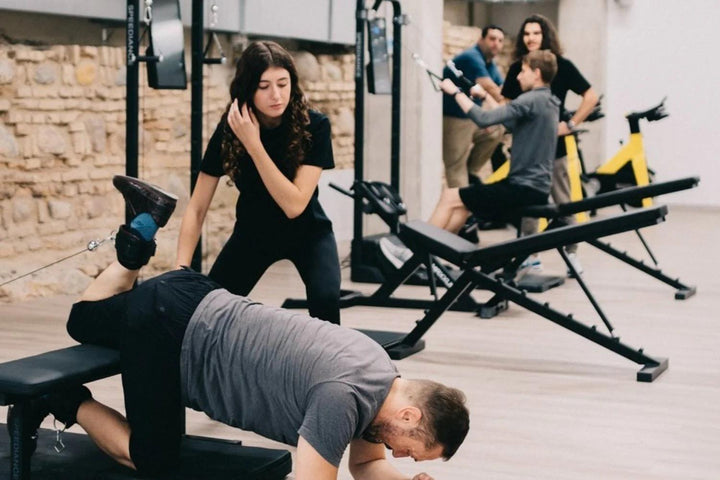 Ein Trainer coacht einen Kunden in einem Studio mit Steinwänden